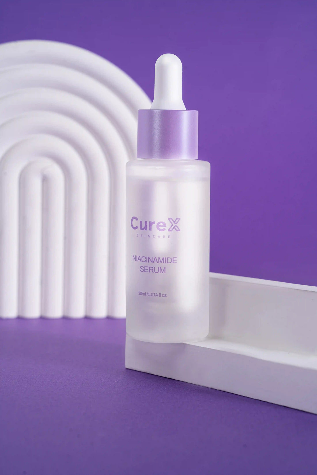 CureX niacinamide serum bottle and packaging on a purple background